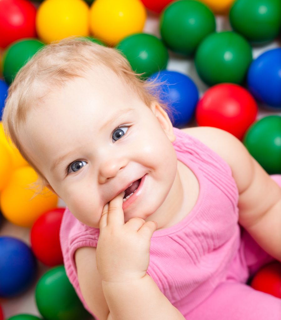 Une petite fille souriante avec des balles multicolores