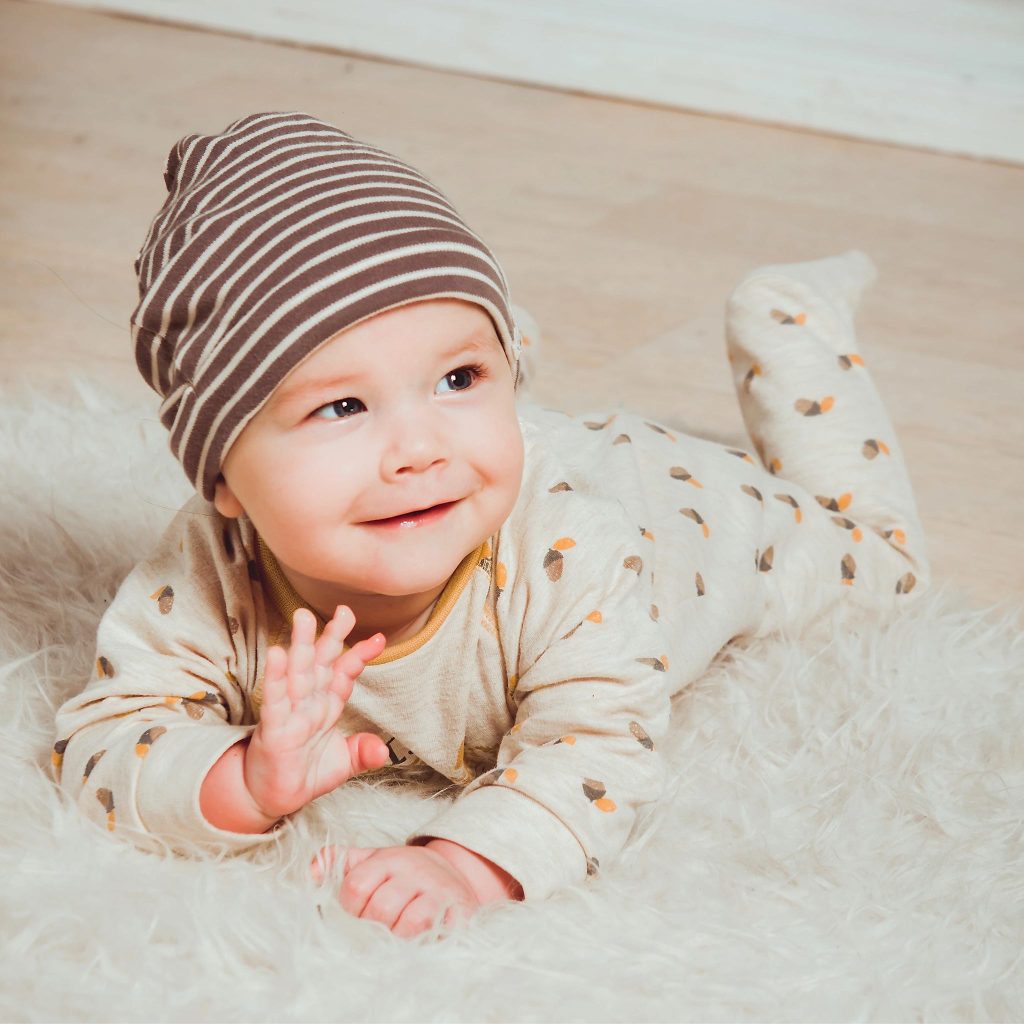 Un bébé souriant sur un tapis